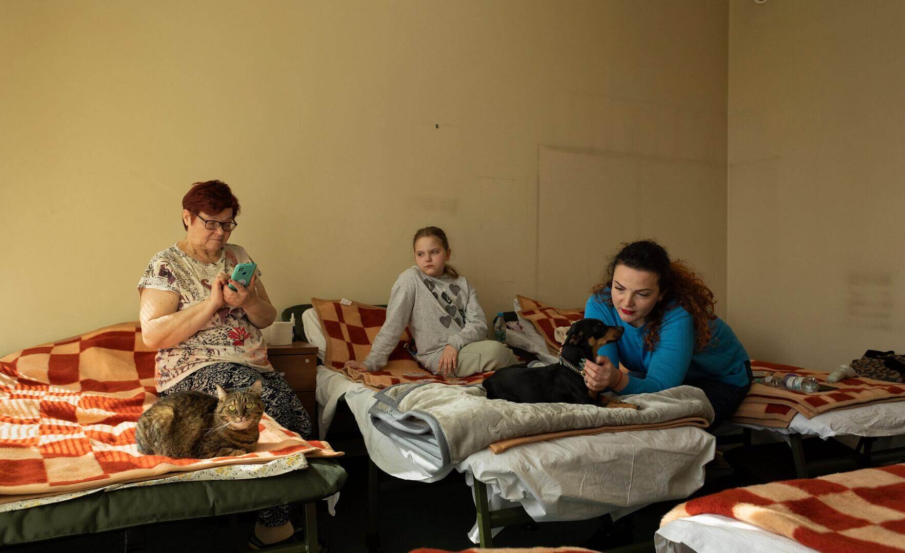 REFUGIADAS. Daryna Vasylieva con su nieta, Natalia, y su hija, Maria Skvortsova, junto a sus mascotas en un antiguo edificio de oficinas en Zabki, Polonia.